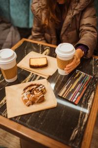 een vrouw aan een tafel met twee kopjes koffie bij Hotel Belleclaire Central Park in New York