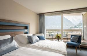 a hotel room with a bed and a large window at Metropole Swiss Quality Hotel in Interlaken