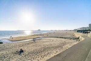 a beach with people on the sand and the ocean at Luxury Living by the Sea Matosinhos Marvel in Matosinhos