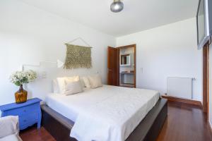 a bedroom with a large white bed with a blue night stand at Luxury Living by the Sea Matosinhos Marvel in Matosinhos