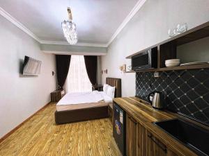 um pequeno quarto com uma cama e uma janela em Апартаменты рядом с Hilton em Dushanbe