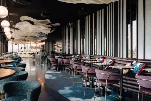 een restaurant met paarse stoelen en tafels en ramen bij DoubleTree by Hilton Amsterdam Centraal Station in Amsterdam