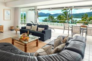 ein Wohnzimmer mit einem Sofa und einem Tisch in der Unterkunft Bella Vista East 4 Oceanview, Golf Buggy, Valet Service & Shared Pool in Hamilton Island