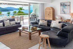 ein Wohnzimmer mit einem blauen Sofa und einem Tisch in der Unterkunft Bella Vista East 4 Oceanview, Golf Buggy, Valet Service & Shared Pool in Hamilton Island