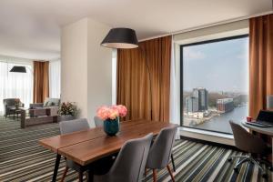 uma sala de jantar com uma mesa e uma grande janela em Leonardo Royal Hotel Amsterdam em Amesterdão