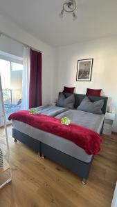 um quarto com uma cama grande e um cobertor vermelho em CityLake G23 Apartments mit kostenlosem Parkgaragen-Stellplatz !! em Gmunden