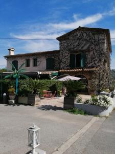 um edifício de pedra com uma mesa e cadeiras em frente em Auberge les Aromes em Grasse