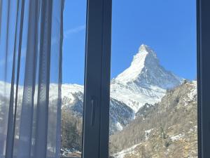 widok na pokrytą śniegiem górę przez okno w obiekcie Hotel Bristol w mieście Zermatt