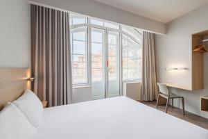 een hotelkamer met een bed en een raam bij Moov Hotel Porto Centro in Porto