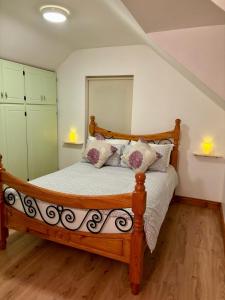 een slaapkamer met een houten bed met kussens bij Seafront House in Sligo