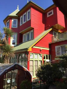 ein großes rotes Haus mit grünem Dach in der Unterkunft Eco Hostal Offenbacher-Hof in Viña del Mar