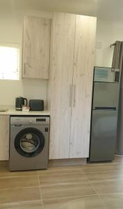 een keuken met een wasmachine en een koelkast bij Avonlea Guest House in Kloof