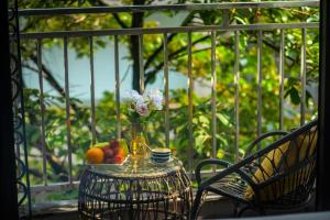 a table with a vase of flowers and fruit on a balcony at Eliana Premio Hotel Hanoi in Hanoi