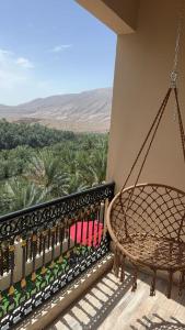 - une balançoire sur un balcon avec vue sur le désert dans l'établissement WADI BANI KALED REST HOUSE, à Dawwah