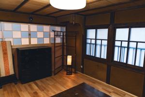 una habitación vacía con una habitación con ventanas y una mesa en Johns House じょんのやど, en Himeji