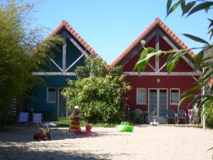 una casa rossa con una sabbiera di fronte di Naturotel a Fort-Mahon-Plage