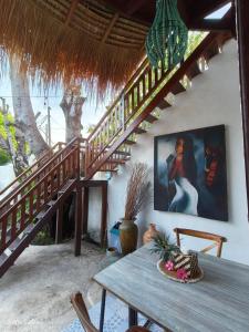 un comedor con una mesa de madera y escaleras en Gili Breeze Tropical Bungalows, en Gili Trawangan