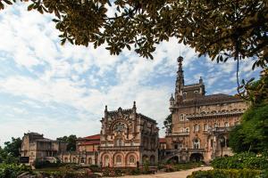 an old building with a clock tower in front of it at Palace Hotel do Bussaco in Luso