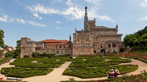 an old building with a garden in front of it at Palace Hotel do Bussaco in Luso