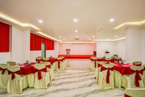 a banquet hall with red and yellow tables and chairs at KAMAT'S DAFFODIL RESORT GOA in Pilerne