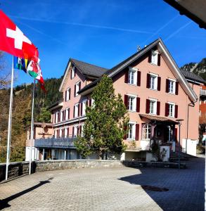 una bandiera di fronte a un edificio rosa di Pilgerhaus Maria-Rickenbach - Anreise nur via Luftseilbahn möglich a Dallenwil