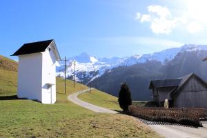 un piccolo edificio bianco su una collina con una strada di Pilgerhaus Maria-Rickenbach - Anreise nur via Luftseilbahn möglich a Dallenwil