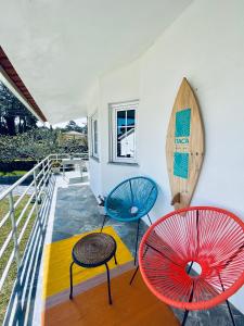 - un balcon avec deux chaises et une planche de surf dans l'établissement Itaca Experience Playa do Cabedelo, à Viana do Castelo