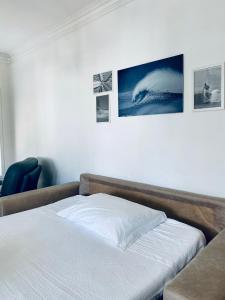 - un lit dans une chambre avec des photos sur le mur dans l'établissement Itaca Experience Playa do Cabedelo, à Viana do Castelo