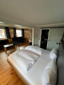 een groot wit bed in een kamer met houten vloeren bij Hotel Lamm in Baiersbronn