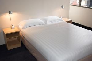 A bed or beds in a room at Siesta Sydney