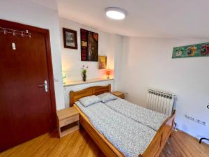 a bedroom with a bed and a wooden door at Hostel Vagabond in Sarajevo