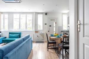 uma sala de estar com um sofá azul e uma mesa em ParisMyHome - AIR COND, 2 SHOWERS, 2 WC em Paris