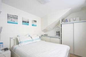 um quarto branco com uma cama e uma escada em ParisMyHome - AIR COND, 2 SHOWERS, 2 WC em Paris