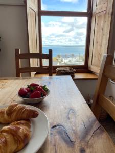 stół z talerzem chleba i miską owoców w obiekcie HUER'S WATCH a beautifully presented PRIVATE APARTMENT with far reaching VIEWS Over ST IVES HARBOUR and BAY and FREE ONSITE PARKING for LARGER GROUPS book along with our Connecting TWO SISTER APARTMENTS w St Ives