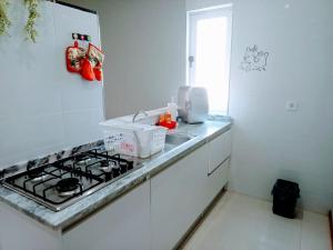 a white kitchen with a stove and a sink at Apartamento T1 in Praia