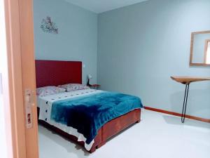 a bedroom with a bed with a red headboard at Apartamento T1 in Praia