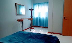 a room with a bed and a cross on the wall at Apartamento T1 in Praia