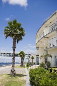 ein Gebäude mit Palmen neben einem Strand in der Unterkunft Hotel Setre Kobe Maiko in Kōbe