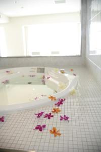 ein Badezimmer mit einer Badewanne mit Blumen auf dem Boden in der Unterkunft Hotel Setre Kobe Maiko in Kōbe