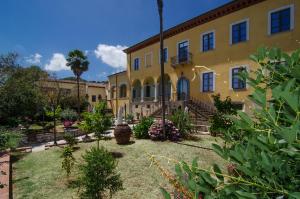 een groot geel gebouw met een fontein in een tuin bij Hotel Villa Cheli in Lucca