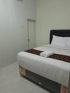 - une chambre avec un lit et 2 serviettes dans l'établissement Jogja Amor Hotel, à Demangan