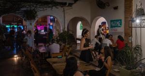 un gruppo di persone seduti ai tavoli in un ristorante di Nomad Hostel a Santa Cruz de la Sierra