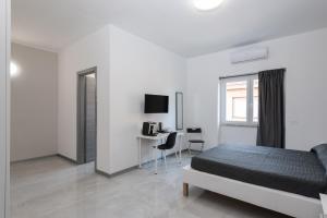 a white bedroom with a bed and a desk at Travelershome Ciampino Airport GuestHouse 600m to Airport in Ciampino