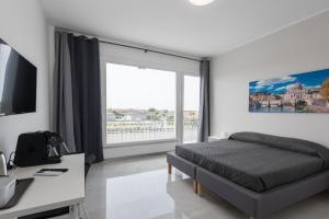 a bedroom with a bed and a large window at Travelershome Ciampino Airport GuestHouse 600m to Airport in Ciampino