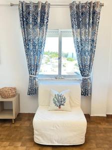 a white chair in a room with a window at MAREA Algarve - Sea view sunny apartment in Alvor in Alvor