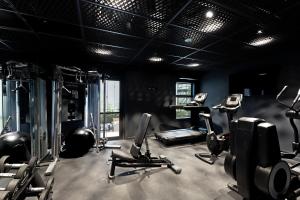 una palestra con diversi tapis roulant e cyclette in una sala di Abstract Hotel ad Auckland