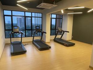 un gimnasio con 4 cintas de correr en una habitación con ventanas en Non Smoking Theda Antara Putrajaya with Wifi and Netflix, en Putrajaya