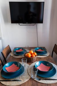 une table en bois avec des assiettes et des bols de fruits dans l'établissement Orange Sunset, à Draguignan