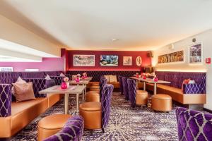 um restaurante com mobiliário roxo, mesas e cadeiras em CityClass Hotel Alter Markt em Colónia