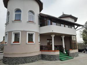 a large white house with some stairs in front of it at Pensiunea Crown Royal in Alba Iulia